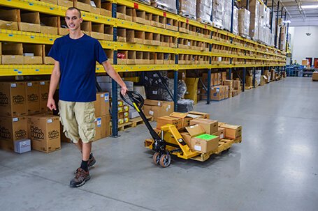 Man pulling loaded pallet jack